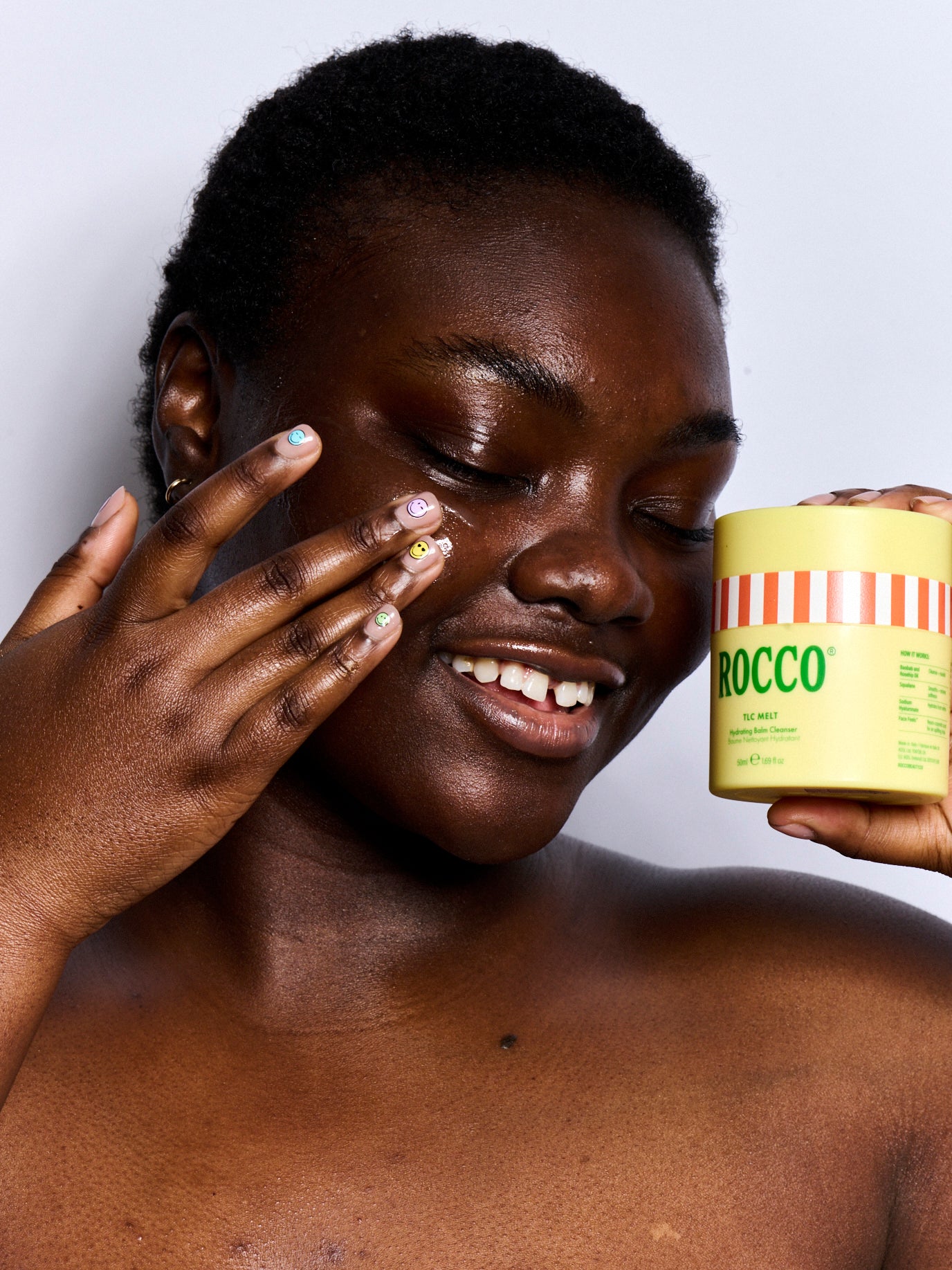 Person holding a jar labelled ROCCO TLC Melt against a plain background