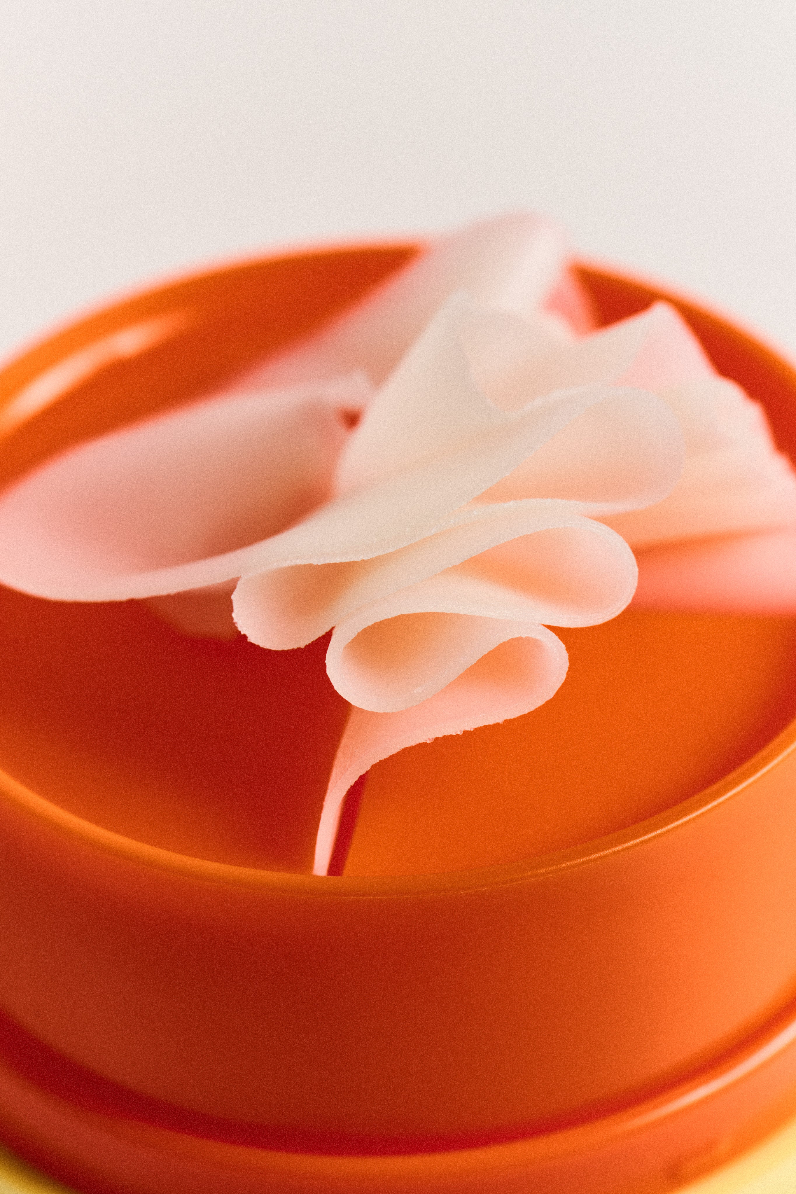TLC Melt texture image ontop of orange lid of product