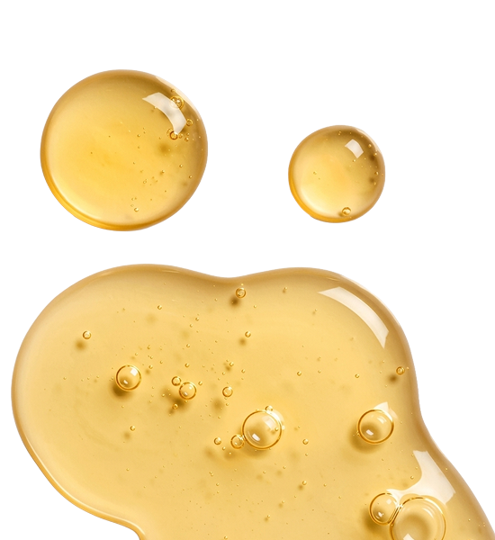 Close-up of yellow Baobab liquid droplets and a puddle on a white background